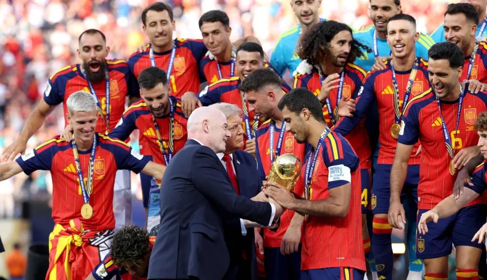 EAST RUTHERFORD, NEW JERSEY - JULY 19: Rodri #16 of Spain is presented the FIFA World Cup Winner?s Trophy by U.S. President Donald Trump and FIFA President Gianni Infantino after the team?s victory following during the FIFA World Cup 2026 Final match between Spain and Argentina at New York New Jersey Stadium on July 19, 2026 in East Rutherford, New Jersey. Carl Recine/Getty Images/AFP (Photo by Carl Recine/GETTY IMAGES NORTH AMERICA/Getty Images via AFP)