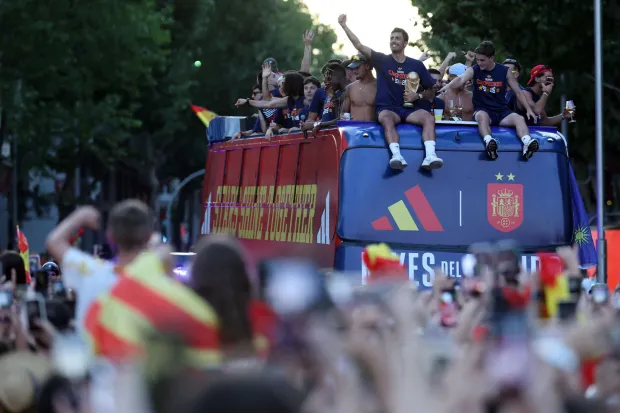 Spain's midfielder Rodri holds their trophy as Spain's players parade onboard an open-top bus through the streets of Madrid on July 20, 2026, one day after the national football team won their second World Cup title following a 1-0 victory against Argentina. Spain's World Cup winners come back home to a heroes' welcome in Madrid, where a million fans are expected to greet them after a night of raucous celebrations across the country. (Photo by Thomas COEX/AFP)