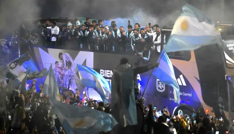 Argentina's national football team rides aboard an open-top bus towards the Argentine Football Association (AFA) training camp in Ezeiza, Buenos Aires Province, on July 20, 2026, after returning from the United States following its defeat in the 2026 FIFA World Cup final. (Photo by Luis ROBAYO/AFP)