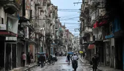 People walk along a street during a nationwide blackout in Havana on July 10, 2026. Cuba suffered its second nationwide blackout in five days on July 10 as twin energy and economic crises, compounded by a six-month US fuel blockade, caused the electricity grid to collapse. (Photo by YAMIL LAGE/AFP)