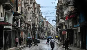 People walk along a street during a nationwide blackout in Havana on July 10, 2026. Cuba suffered its second nationwide blackout in five days on July 10 as twin energy and economic crises, compounded by a six-month US fuel blockade, caused the electricity grid to collapse. (Photo by YAMIL LAGE/AFP)