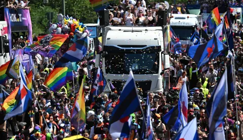 Participants are seen on trucks during the Christopher Street Day (CSD) parade in Berlin on July 25, 2026. This year's CSD parade takes place under the slogan 'Taking a stand is Hot', where various groups will demonstrate in support of diversity, human rights, and the protection of minorities. (Photo by RALF HIRSCHBERGER/AFP)