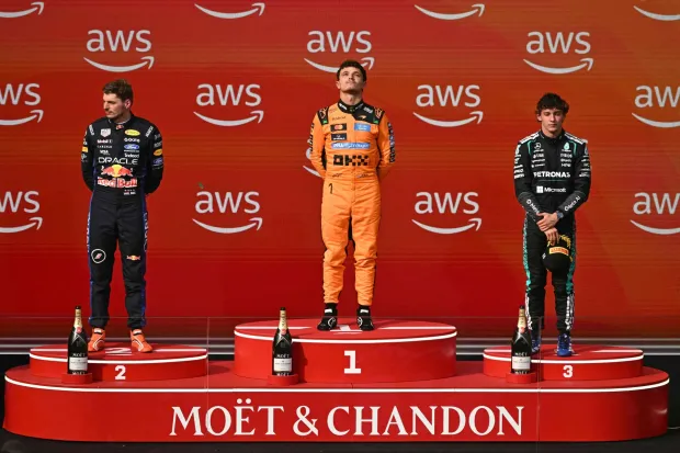 TOPSHOT - (LtoR) Second placed Red Bull Racing's Dutch driver Max Verstappen, winner McLaren's British driver Lando Norris and third placed Mercedes' Italian driver Kimi Antonelli celebrate on the podium after the Formula One Hungarian Grand Prix at the Hungaroring racetrack in Mogyorod near Budapest, Hungary, on July 26, 2026. (Photo by Attila KISBENEDEK/AFP)