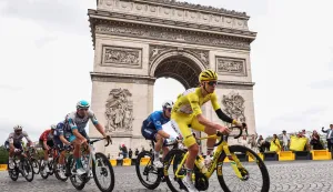 (FILES) This photograph taken on July 27, 2025, shows UAE Team Emirates - XRG team's Slovenian rider Tadej Pogacar wearing the overall leader's yellow jersey cycling with the pack of riders (peloton) past the Arc de Triomphe on Place Charles de Gaulle during the 21st and final stage of the 112th edition of the Tour de France cycling race, 132.3 km between Mantes-la-Ville and Paris' Champs-Elysees Avenue. Tour de France organisers announced on July 25, 2026 that they were shortening the 21st and final final stage of the 2026 edition due to the wildfires ravaging southwest France. The news came after the interior ministry had said that it would need to redeploy officers initially mobilised to provide security for the race, to areas affected by the fire. The 21st stage was due to last 133km and begin west of Paris in Thoiry. Instead, it will start on the Champs Elysees in Paris and take in a couple of extra laps around the famous avenue before joining the main Montmartre circuit, and will last only 89km. (Photo by Anne-Christine POUJOULAT/AFP)