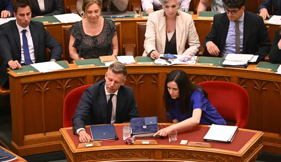 Lawmakers including Hungarian Prime Minister Peter Magyar (first row, L) and Foreign Minister Anita Orban (R) vote on a constitutional amendment at the extraordinary session of parliament at the House of Representatives in Budapest, Hungary on July 13, 2026. The Hungarian parliament on on July 13, 2026 passed a constitutional tweak to oust the country's president, whom new Prime Minister Peter Magyar accuses of being a "puppet" of hardline ex-leader Viktor Orban. Lawmakers from Magyar's Tisza party broke into a half-minute-long standing ovation after voting to eject unpopular President Tamas Sulyok from office by 139 votes to six, in a ballot boycotted by Orban's nationalist Fidesz party. (Photo by Attila KISBENEDEK/AFP)