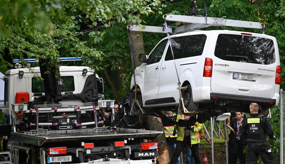 Police get the van lifted on a truck to remove it on July 26, 2026 in the Tiergatren Park in Berlin, after it was used in the car-ramming attack in the Tiergarten park that left one woman dead and 29 other people injured on the sidelines of the Christopher Street Day (CSD) parade the evening before. German police on July 26, 2026 were hunting for the prime suspect in what authorities called an Islamist terror attack on the outskirts of Berlin Pride late on July 25, 2026. The incident shattered what had been a day of celebration for hundreds of thousands attending Christopher Street Day (CSD), one of Europe's largest Pride events. (Photo by RALF HIRSCHBERGER/AFP)