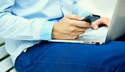 Young man working with laptop, man's hands on notebook computer, business person in casual clothes in the streetmobitel laptop kompjuter ilustracija magnific