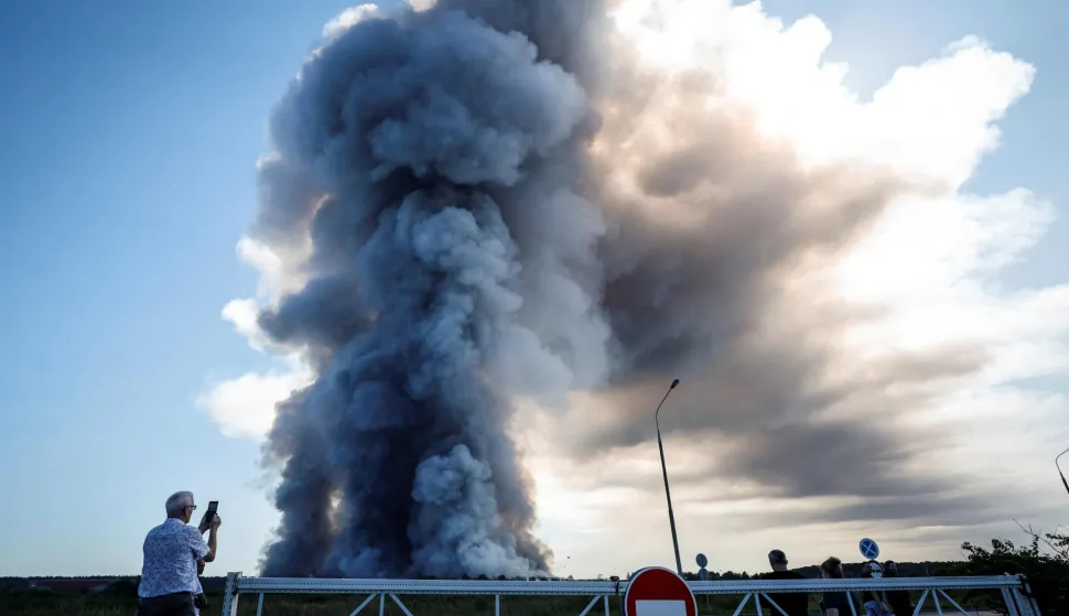 A local resident takes a picture of the smoke of a fire at the Russian e-commerce firm Wildberries' logistics complexes in the town of Elektrostal outside Moscow on July 18, 2026. A Ukrainian drone attack on two logistics centres in Russia killed eight people and injured 24, officials said on July 18, 2026, when the Moscow region reported a new wave of drone strikes. Russian e-commerce firm Wildberries said its logistics complexes in Kotovsk and Elektrostal, in the Tambov and Moscow regions respectively, came under attack. One person was killed and 37 were injured at the Elektrostal warehouse, according to the region's governor, Andrei Vorobyov. (Photo by TATYANA MAKEYEVA/AFP)