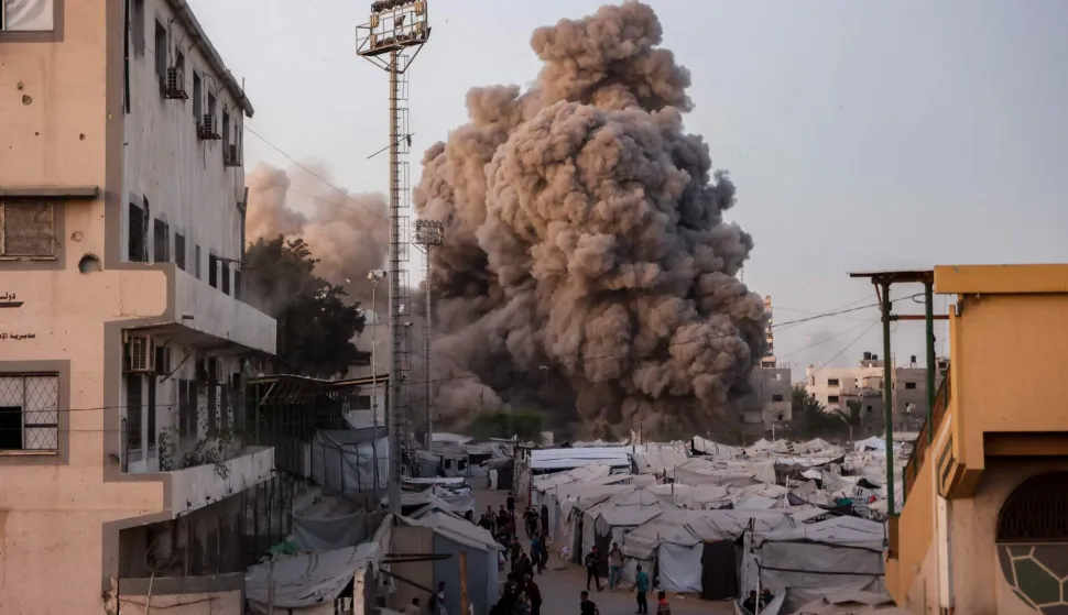 Palestinians run for cover as smoke and fire rise during an Israeli strike on the the Al-Muttaqin Mosque in Gaza City on July 28, 2026. Gaza remains gripped by daily violence, with both the Israeli military and Hamas accusing one another of violating the truce in effect since October 10. The war flattened swathes of the territory, displaced most of the population at least once, and left hundreds of thousands of people living in tents and temporary shelters. (Photo by Omar AL-QATTAA/AFP)