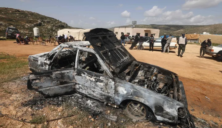 Palestinians stand near a vehicle that was destroyed following an Israeli settlers attack on the outskirts of Al-Lubban ash-Sharqiya village, south of Nablus in the occupied West Bank, on April 6, 2026. Violence more broadly in the West Bank, which Israel has occupied since 1967, has risen sharply since the October 7, 2023 Hamas attack on Israel triggered the Gaza war. It has continued despite a ceasefire in place since October 10. (Photo by JAAFAR ASHTIYEH/AFP)