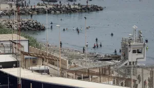 A photograph taken from the outskirts of the Moroccan town of Fnideq on the Morocco-Spain border shows migrants attempting to reach Spain's North African enclave of Ceuta by swimming across the maritime border, on July 31, 2026. The European Union on July 31 scrambled to contain one of the largest migrant crises faced by the block in recent years, after tens of thousands of people poured into into Spain's North African Ceuta enclave in just days. (Photo by Abdel Majid BZIOUAT/AFP)