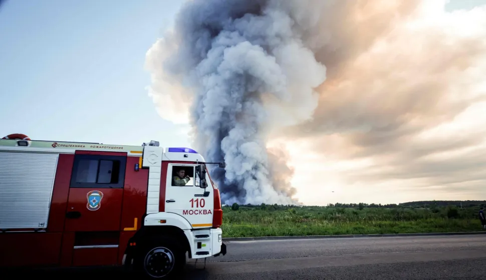 Firefighters drive past the smoke of a fire at the Russian e-commerce firm Wildberries' logistics complexes in the town of Elektrostal outside Moscow on July 18, 2026. A Ukrainian drone attack on two logistics centres in Russia killed eight people and injured 24, officials said on July 18, 2026, when the Moscow region reported a new wave of drone strikes. Russian e-commerce firm Wildberries said its logistics complexes in Kotovsk and Elektrostal, in the Tambov and Moscow regions respectively, came under attack. One person was killed and 37 were injured at the Elektrostal warehouse, according to the region's governor, Andrei Vorobyov. (Photo by TATYANA MAKEYEVA/AFP)