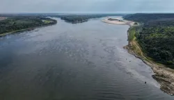 An aerial view shows the splitting point of Danube with Bala branch (L) and Old Danube (R), the place where a controlled underwater explosion took place on the riverbed of the Danube River in Izvoarele village, on August 3, 2026. The blast aimed at deepening the channel and diverting a higher volume of water toward the cooling systems of the Cernavoda Nuclear Power Plant. Local authorities and plant engineers authorized the blasting operations to counteract critically low water levels caused by a prolonged summer heatwave, ensuring the continuous and safe operation of the facility's reactors. (Photo by Daniel MIHAILESCU/AFP)