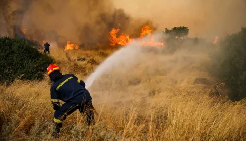 Firefighters work to extinguish a wildfire raging since four days in the Megara Region, west of Athens on August 3, 2026. Wildfires that have raged for four days west of Athens remained a threat on August 3, 2026, with flames flaring up again despite easing winds and the deployment of firefighting aircraft. Firefighters reported a slight improvement in conditions earlier in the day, but authorities later warned of fresh flare-ups on one of the main fire fronts near Megara, about 30 kilometres (19 miles) west of the capital. (Photo by Aris Oikonomou/AFP)