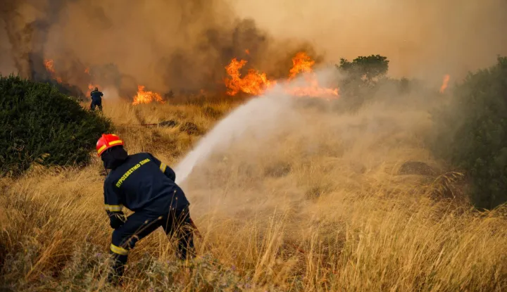 Firefighters work to extinguish a wildfire raging since four days in the Megara Region, west of Athens on August 3, 2026. Wildfires that have raged for four days west of Athens remained a threat on August 3, 2026, with flames flaring up again despite easing winds and the deployment of firefighting aircraft. Firefighters reported a slight improvement in conditions earlier in the day, but authorities later warned of fresh flare-ups on one of the main fire fronts near Megara, about 30 kilometres (19 miles) west of the capital. (Photo by Aris Oikonomou/AFP)
