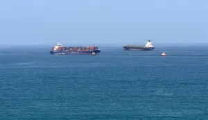 (FILES) A cargo ship is pictured off coast of the Khor Fakkan Container Terminal, the only natural deep-sea port in the region and one of the major container ports in Sharjah Emirate, along the Gulf of Oman on June 28, 2026. For 115 days, captain Mohammad Shafiqul Islam was stranded in the high seas of the Gulf, watching missiles light up the night sky and rationing food and water for his crew. "I tried to stay calm because I was responsible for 31 lives, a ship worth  million and cargo valued at .2 million," the 51-year-old Bangladeshi mariner told AFP, back home after the ordeal. (Photo by AFP)/