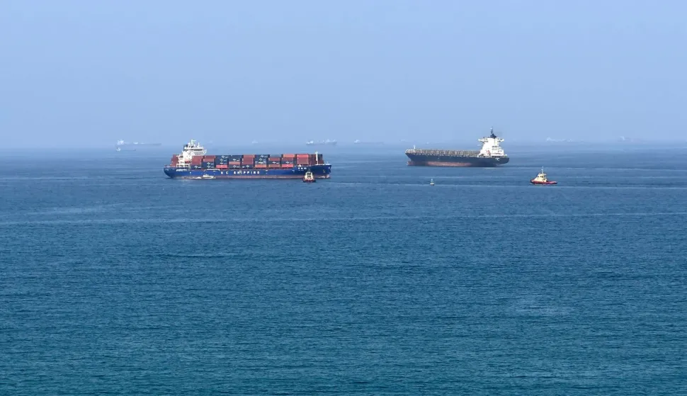 (FILES) A cargo ship is pictured off coast of the Khor Fakkan Container Terminal, the only natural deep-sea port in the region and one of the major container ports in Sharjah Emirate, along the Gulf of Oman on June 28, 2026. For 115 days, captain Mohammad Shafiqul Islam was stranded in the high seas of the Gulf, watching missiles light up the night sky and rationing food and water for his crew. "I tried to stay calm because I was responsible for 31 lives, a ship worth $40 million and cargo valued at $8.2 million," the 51-year-old Bangladeshi mariner told AFP, back home after the ordeal. (Photo by AFP)/