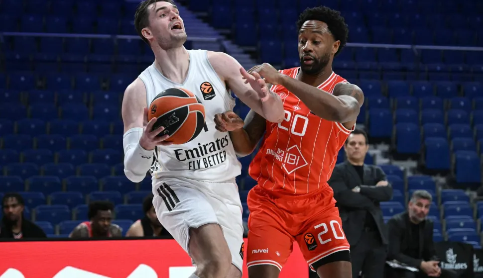 Real Madrid's Croatian forward #11 Mario Hezonja drives the ball against Hapoel IBI Tel Aviv's US forward #20 Levi Randolph during the empty-stadium Euroleague basketball match between Real Madrid Baloncesto and Hapoel IBI Tel-Aviv at the Movistar arena in Madrid on March 24, 2026. (Photo by Javier SORIANO/AFP)