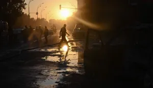 EDITORS NOTE: Graphic content/A person crosses the street past a damaged car and debris on the road following a Russian ballistic missile strike in the Ukrainian capital of Kyiv on August 1, 2026, amid the Russian invasion in Ukraine. Russian attacks on Ukraine's capital killed at least nine people and wounded more than two dozen others, local officials said on August 1, 2026, with strikes damaging homes and causing fires across the city. As Moscow has increased its long-range strikes on Ukrainian towns and cities, Kiev has pressed its allies for air defence support. The United Nations found June 2026 was the deadliest month for civilians in Ukraine since April 2022. (Photo by Genya SAVILOV/AFP)