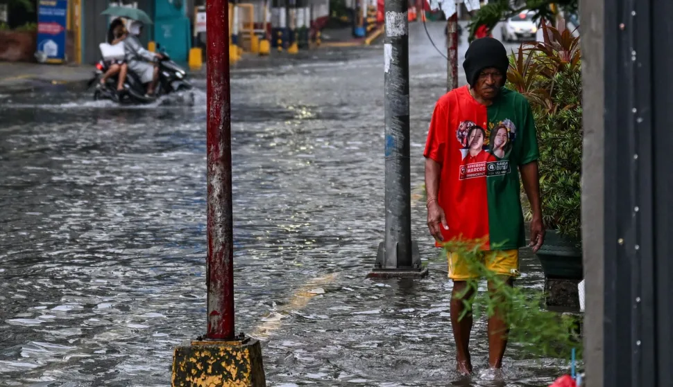 A man wades through a flooded street due to heavy rains brought by the southwest monsoon in Manila on August 9, 2026. (Photo by Jam STA ROSA/AFP)