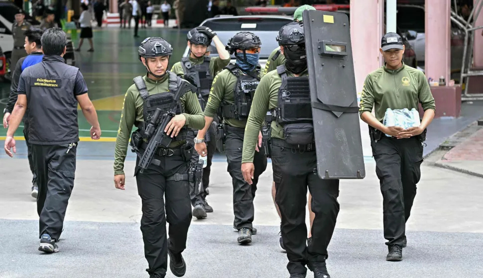 Armed police walk through the school premises after a shooting in Bang Kruai district, Nonthaburi province, north of Thailand's capital Bangkok, on August 7, 2026. At least two people were killed and several others wounded in a school shooting north of the Thai capital Bangkok on August 7, a Nonthaburi provincial official told AFP. (Photo by Lillian SUWANRUMPHA/AFP)
