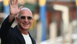 (FILES) US founder of Amazon, Jeff Bezos waves as he leaves the Aman Hotel in Venice on June 25, 2025. Liverpool's owners, August 14, have agreed to sell a minority stake in the Premier League club to a consortium including Amazon founder Jeff Bezos. (Photo by Marco BERTORELLO/AFP)