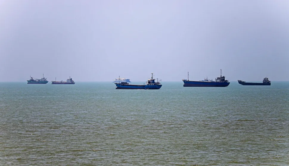TOPSHOT - In this picture obtained from Iran's ISNA news agency on June 18, 2026, vessels are seen anchored in Bandar Abbas along the Strait of Hormuz. Oil prices tumbled after Trump and his Iranian counterpart separately signed their accord to end the Middle East war, with the Strait of Hormuz to reopen but two months of negotiations lying ahead. (Photo by AMIRHOSSEIN KHORGOOEI/ISNA/AFP)/
