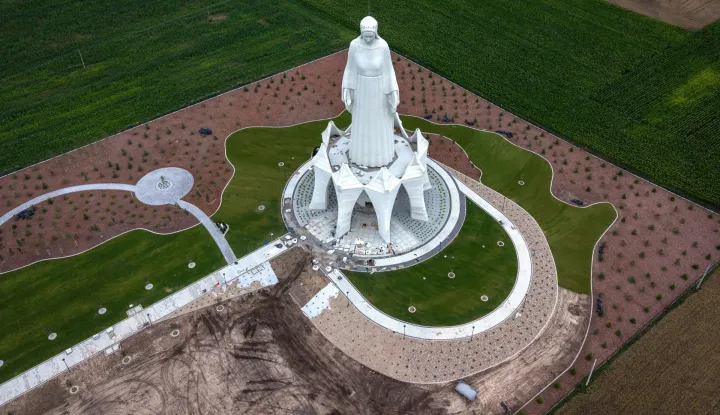 This aerial photo taken on July 22, 2026, shows a statue of the Virgin Mary during finishing works at the construction site in Konotopie village, next to Torun, central Poland. In a nondescript village in northern-central Poland, a statue of the Virgin Mary, towers above what residents hope is the traditionally Catholic country's newest pilgrimage destination. At 55 meters high, the concrete and steel beam figure in Konotopie is the tallest Marian statue in Europe, and second in the world. (Photo by Wojtek RADWANSKI/AFP)