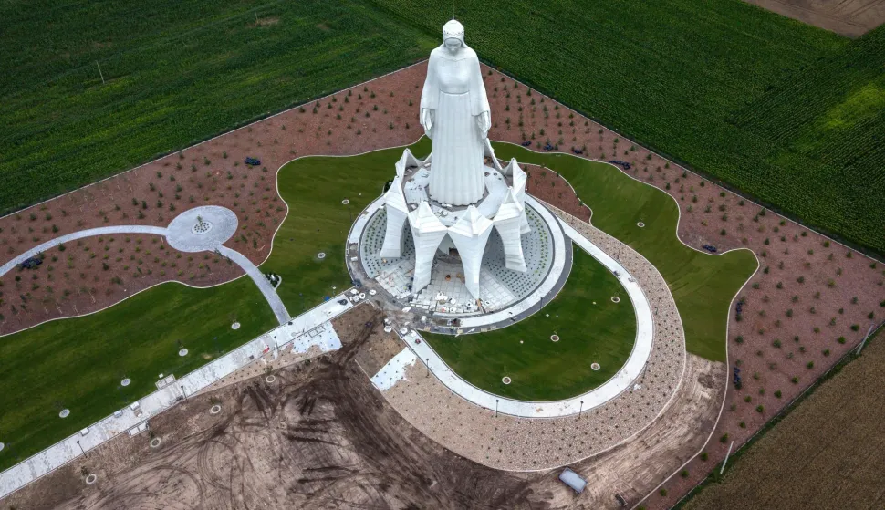 This aerial photo taken on July 22, 2026, shows a statue of the Virgin Mary during finishing works at the construction site in Konotopie village, next to Torun, central Poland. In a nondescript village in northern-central Poland, a statue of the Virgin Mary, towers above what residents hope is the traditionally Catholic country's newest pilgrimage destination. At 55 meters high, the concrete and steel beam figure in Konotopie is the tallest Marian statue in Europe, and second in the world. (Photo by Wojtek RADWANSKI/AFP)