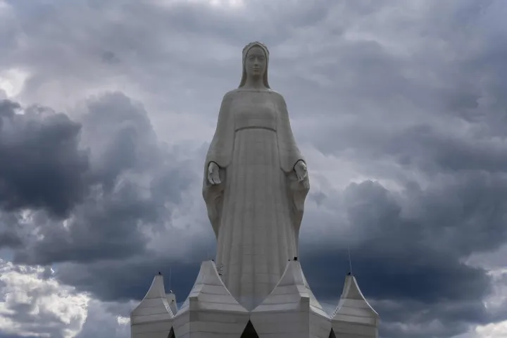 A statue of the Virgin Mary is seen behind the fence of the construction site in Konotopie village, next to Torun, central Poland on July 22, 2026. In a nondescript village in northern-central Poland, a statue of the Virgin Mary, towers above what residents hope is the traditionally Catholic country's newest pilgrimage destination. At 55 meters high, the concrete and steel beam figure in Konotopie is the tallest Marian statue in Europe, and second in the world. (Photo by Wojtek RADWANSKI/AFP)