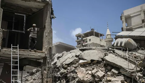A construction worker rests as he removes debris from a damaged building next to a flattened building at the site of an earlier Israeli military strike on a neighbourhood in the southern Lebanese coastal city of Tyre on June 23, 2026. On June 22, 2026, mediators Pakistan and Qatar said that Tehran and Washington had agreed to set up a "de-confliction cell" to limit flare-ups in Lebanon following talks in Switzerland on ending the wider Middle East war, which Tehran has linked to halting the parallel conflict in Lebanon. (Photo by Joseph EID/AFP)/