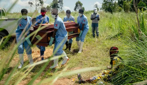 (FILES) Members of a Congolese Red Cross team carry the coffin of a woman suspected of having died from Ebola virus disease during her safe burial at a cemetery in Bunia on June 7, 2026. An Ebola outbreak in the Democratic Republic of Congo has killed 2,011 people out of 4,381 confirmed cases of the virus, Congolese officials said on Tuesday.The latest toll for the disease, which has hit the DRC's conflict-plagued eastern and northeastern regions, puts it close behind the country's deadliest Ebola outbreak in 2018 to 2020 when nearly 2,300 people died. (Photo by Jospin Mwisha/AFP)