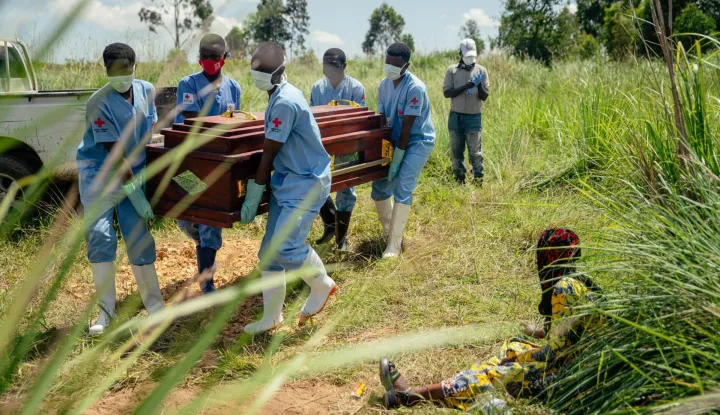 (FILES) Members of a Congolese Red Cross team carry the coffin of a woman suspected of having died from Ebola virus disease during her safe burial at a cemetery in Bunia on June 7, 2026. An Ebola outbreak in the Democratic Republic of Congo has killed 2,011 people out of 4,381 confirmed cases of the virus, Congolese officials said on Tuesday.The latest toll for the disease, which has hit the DRC's conflict-plagued eastern and northeastern regions, puts it close behind the country's deadliest Ebola outbreak in 2018 to 2020 when nearly 2,300 people died. (Photo by Jospin Mwisha/AFP)