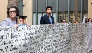 OAKLAND, CALIFORNIA - AUGUST 18: Family and advocates of young people that allegedly died from impacts of social media stand with a banner outside the Ronald V. Dellums Federal Building and U.S. Courthouse on August 18, 2026 in Oakland, California. State attorneys general are alleging that Meta attempted to deceive the public by allowing features on their platforms, Facebook and Instagram, that harm children's mental health and are intended to be addictive. Benjamin Fanjoy/Getty Images/AFP (Photo by Benjamin Fanjoy/GETTY IMAGES NORTH AMERICA/Getty Images via AFP)