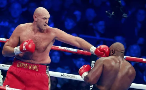 epa10347178 British boxer Tyson Fury (L) in action against British boxer Derek Chisora (R)during the bout between WBC heavyweight champion Tyson Fury and Derek Chisora at the Tottenham Hotspur stadium in London, Britain, 03 December 2022. EPA/TOLGA AKMEN