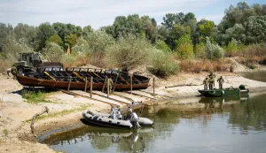Osijek, 19. 8. 2026., Izvlačenje replike rimskog broda Danuvina Alacris na obali Drave Danuvina Alacris; rimski antički brod; replika antičkog broda; muzejski eksponat; riječno plovilo; MORH; vojska