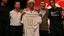 Newly recruited Brazilian football player Ronaldinho stands on stage with the jersey of Ravenna FC during the team presentation in Marina di Ravenna on August 20, 2026. Former Ballon d'Or and World Cup winner Ronaldinho is set to come out of retirement aged 46 to play for Ravenna in the Italian third tier. (Photo by Stefano RELLANDINI/AFP)