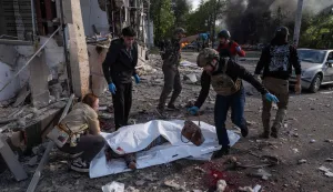 EDITORS NOTE: Graphic content/This handout photograph taken and released on May 5, 2026 by the press service of the 93rd Kholodnyi Yar Separate Mechanized Brigade of the Ukrainian Ground Forces shows people gathered next to a victim of a Russian air attack wrapped in a plastic sheet in Kramatorsk, eastern Donetsk region, amid the Russian invasion of Ukraine. Russian attacks killed 21 people in cities across Ukraine on May 5, 2026, as President Volodymyr Zelensky condemned Moscow's "utter cynicism" for launching deadly strikes while seeking a truce to stage its May 9 patriotic parade. The attacks, hitting the cities of Zaporizhzhia, Kramatorsk and Dnipro, came hours before a Ukrainian-suggested ceasefire. (Photo by IRYNA RYBAKOVA/The 93rd Kholodnyi Yar Separate/AFP)/RESTRICTED TO EDITORIAL USE - MANDATORY CREDIT "AFP PHOTO/IRYNA RYBAKOVA/PRESS SERVICE OF THE 93RD KHOLODNYI YAR SEPARATE MECHANIZED BRIGADE" - NO MARKETING NO ADVERTISING CAMPAIGNS - DISTRIBUTED AS A SERVICE TO CLIENTS