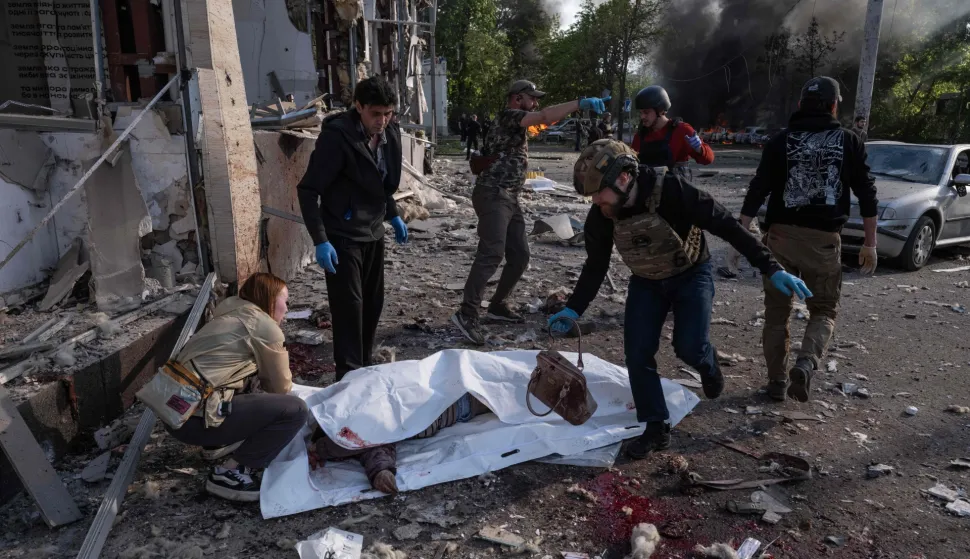 EDITORS NOTE: Graphic content/This handout photograph taken and released on May 5, 2026 by the press service of the 93rd Kholodnyi Yar Separate Mechanized Brigade of the Ukrainian Ground Forces shows people gathered next to a victim of a Russian air attack wrapped in a plastic sheet in Kramatorsk, eastern Donetsk region, amid the Russian invasion of Ukraine. Russian attacks killed 21 people in cities across Ukraine on May 5, 2026, as President Volodymyr Zelensky condemned Moscow's "utter cynicism" for launching deadly strikes while seeking a truce to stage its May 9 patriotic parade. The attacks, hitting the cities of Zaporizhzhia, Kramatorsk and Dnipro, came hours before a Ukrainian-suggested ceasefire. (Photo by IRYNA RYBAKOVA/The 93rd Kholodnyi Yar Separate/AFP)/RESTRICTED TO EDITORIAL USE - MANDATORY CREDIT "AFP PHOTO/IRYNA RYBAKOVA/PRESS SERVICE OF THE 93RD KHOLODNYI YAR SEPARATE MECHANIZED BRIGADE" - NO MARKETING NO ADVERTISING CAMPAIGNS - DISTRIBUTED AS A SERVICE TO CLIENTS