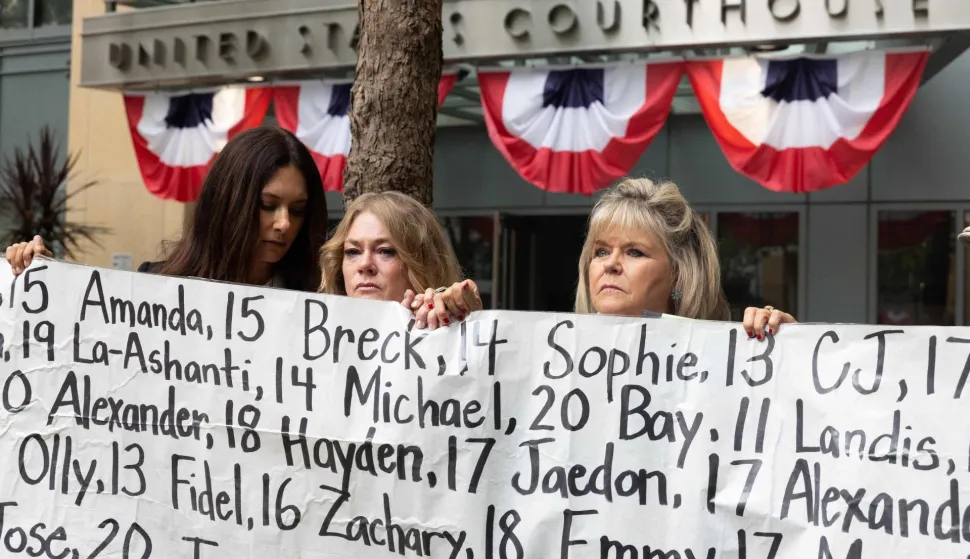 OAKLAND, CALIFORNIA - AUGUST 18: (L-R) Lisa Pearson, Victoria Hinks and Lori Schott hold a banner displaying names of people that allegedly died from impacts of social media stand with a banner outside the Ronald V. Dellums Federal Building and U.S. Courthouse on August 18, 2026 in Oakland, California. State attorneys general are alleging that Meta attempted to deceive the public by allowing features on their platforms, Facebook and Instagram, that harm children's mental health and are intended to be addictive. Benjamin Fanjoy/Getty Images/AFP (Photo by Benjamin Fanjoy/GETTY IMAGES NORTH AMERICA/Getty Images via AFP)