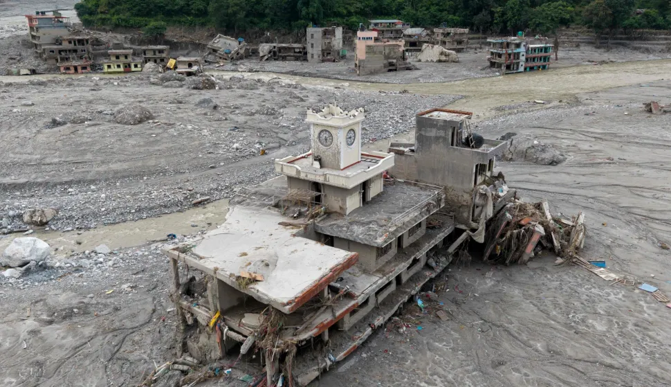 An aerial view shows damaged building in the aftermath of flash floods, near Trishuli river at Betrawati in Nepal's Nuwakot district on August 29, 2026. More than 3,000 people were listed as missing on August 30, with another 768 confirmed dead, after the flash floods and landslides that hit the Nepal-Tibet border. (Photo by Prabin RANABHAT/AFP)