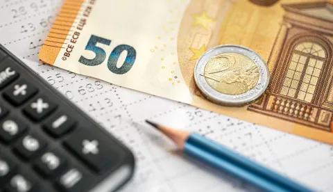 Calculator, money and pencil close-up on a blurred background, the concept of tax calculations and finance.