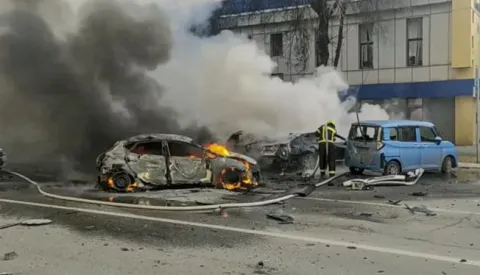 epa11049542 A handout photo made available by the Russian Emergency Ministry press service shows Russian firefighters extinguishing burning cars after shelling in Belgorod, Russia, 30 December 2023. 12 adults and two children were killed due to shelling by the Ukrainian Armed Forces, the press service of the Russian Ministry of Emergency Situations reported 30 December. On 24 February 2022, Russian troops entered Ukrainian territory in what the Russian president declared a 'Special Military Operation', starting an armed conflict that has provoked destruction and a humanitarian crisis. EPA/RUSSIAN EMERGENCIES MINISTRY HANDOUT HANDOUT EDITORIAL USE ONLY/NO SALES HANDOUT EDITORIAL USE ONLY/NO SALES