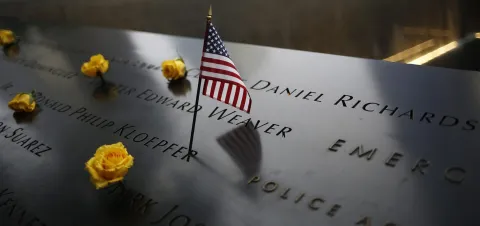 epa05534794 An American flag stands amongst names on the 9/11 memorial before the start of the 15th anniversary memorial service to 9/11 victims in New York, New York, USA, 11 September 2016. On 11 September 2001, during a series of coordinated terror attacks using hijacked airplanes, two airplanes were flown into the World Trade Center's twin towers causing the collapse of both towers. A third plane targeted the Pentagon and fourth plane heading towards Washington, DC ultimately crashed into a field. The unprecedented attack claimed the lives of almost 3,000 people. EPA/JOHN TAGGART