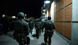 Armed police officers arrive at the Metropolitan Detention facility in the Brooklyn borough of New York, where ousted president Nicolas Maduro is expected to be held, on January 3, 2026 in New York City. President Donald Trump said January 3 that the United States will "run" Venezuela and tap its huge oil reserves after seizing leftist leader Nicolas Maduro during a bombing raid on Caracas.Trump's announcement came hours after a lightning pre-dawn attack in which special forces grabbed Maduro and his wife -- while air strikes pounded sites in and around the capital city -- then whisked him out of the country. (Photo by John Lamparski/AFP)