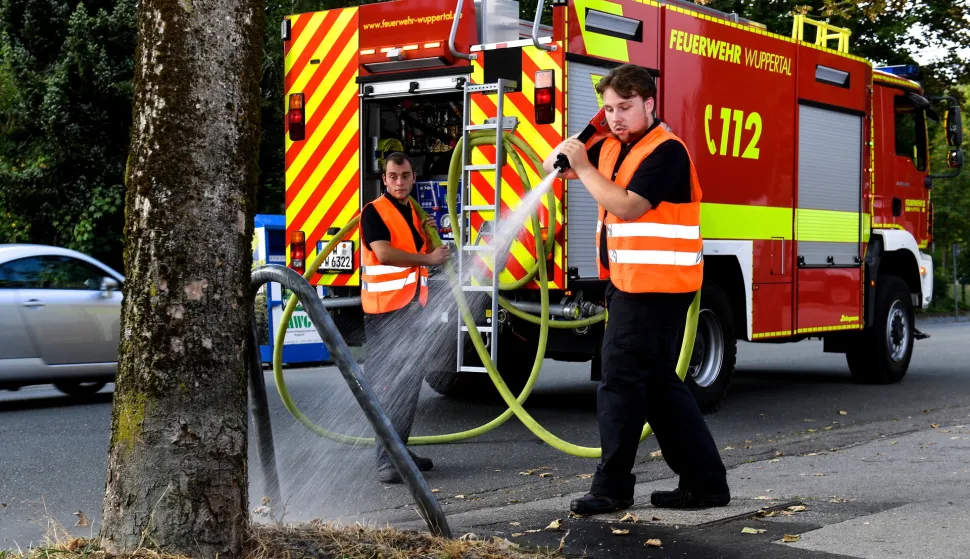 epa06908359 Firemen water trees with extinguishing water in Wuppertal, Germany, 24 July 2018. In North Rhine-Westphalia, towns and communities ask citizens to water trees and plants because of the extreme drought and the persistent heat. EPA/SASCHA STEINBACH