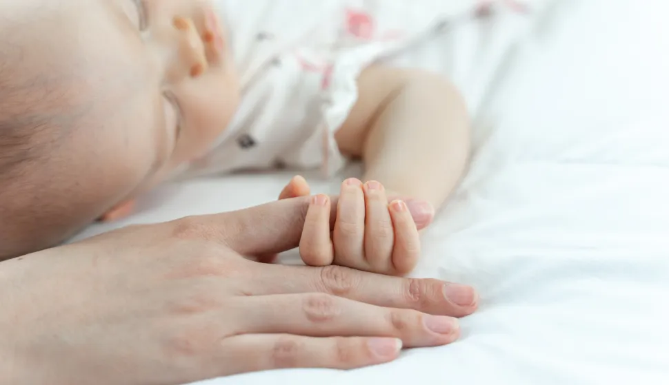 The newborn baby sleeps and grabs the mother's fingermajka beba roditelji novorođenče ruka dijete rođenje ilustracija freepik