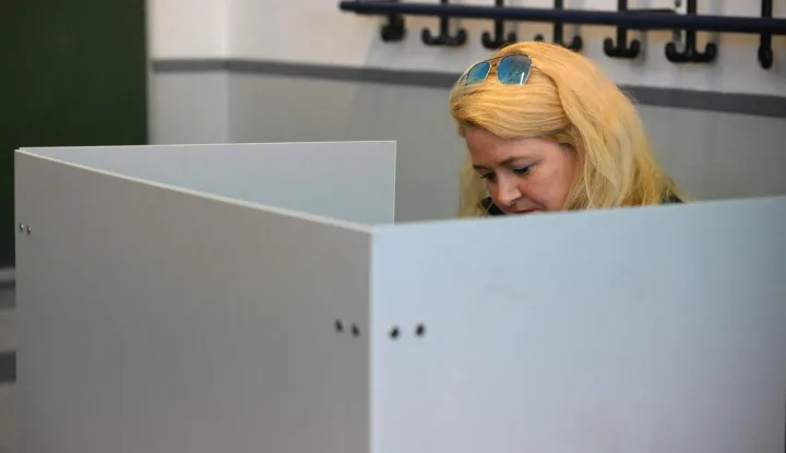 The top candidate of the far-right Alternative for Germany (AfD) party Kristin Brinker stands in a voting booth and fills out her ballot papers before casting her ballot at a polling station in Berlin during regional elections in the German capital on September 20, 2026. Germans began voting in two state elections - the capital Berlin and the northeastern federal state of Mecklenburg-Western Pomerania - where far-right and far-left gains could send new shock waves to Berlin and rock the government of embattled Chancellor Friedrich Merz. (Photo by RALF HIRSCHBERGER/AFP)