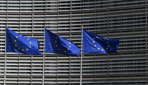 This photograph shows European Union flags outside the EU Commission headquarters in Brussels on March 16, 2026. (Photo by Nicolas TUCAT/AFP)