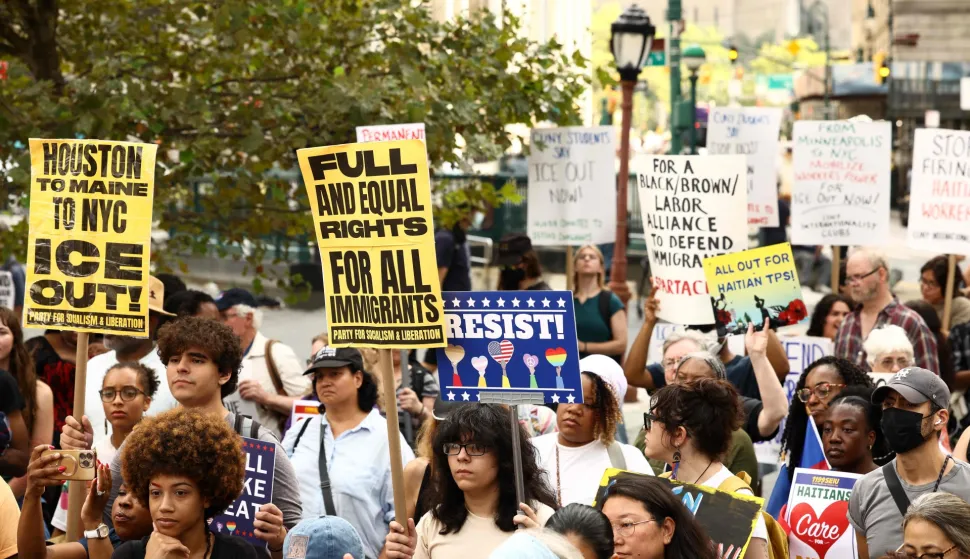 People hold signs during a protest against the termination of Temporary Protected Status (TPS) for the Haitian community and to end mass deportations, at Foley Square in New York City on August 28, 2026. The Supreme Court said in late June 2026 that the Trump administration is allowed to end Temporary Protected Status (TPS) for Haitians and some 6,000 Syrians without judicial review, although the impact of the decision could apply to migrants from many other backgrounds. An estimated 350,000 Haitians live in the United States under the program, with many working in healthcare and construction. (Photo by CHARLY TRIBALLEAU/AFP)